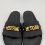 10101.-Klapki-w-kolorze-czarnym-ze-zlotym-metalowym-logo-MOSCHINO.-Otwarty-zaokraglony-nosek.-Klapki-w-stylu-Slip-on-scaled-1.jpg